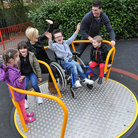 Children and parents enjoying the inclusive wheelchair friendly roundabout Spinmee 